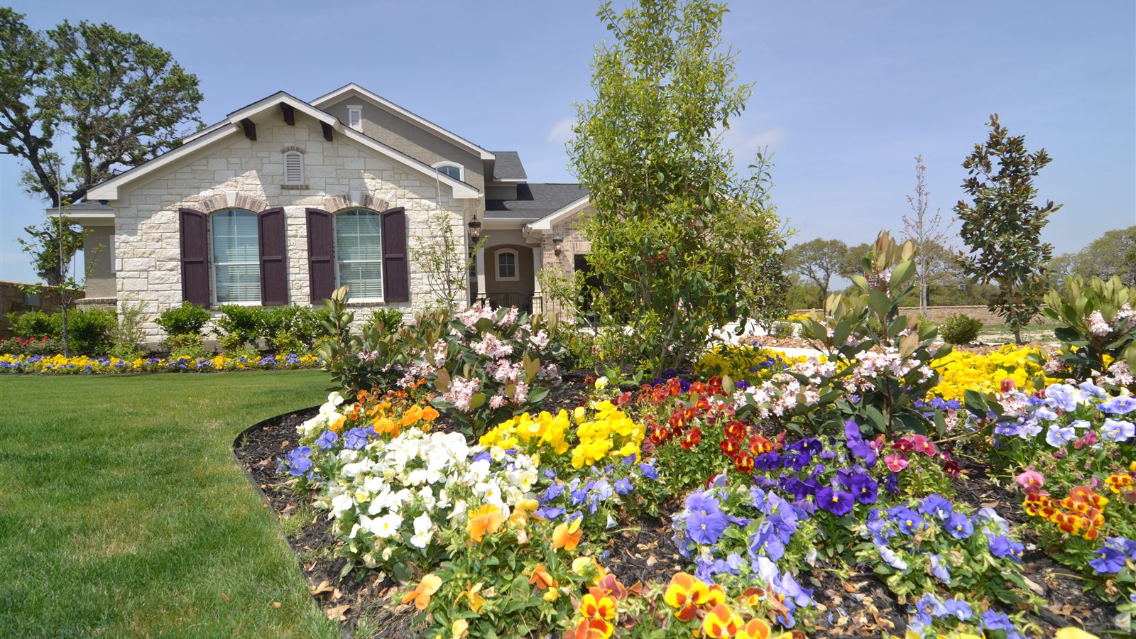 Limestone home with landscaped flower beds in Alamo Ranch, a popular San Antonio community for military relocation buyers