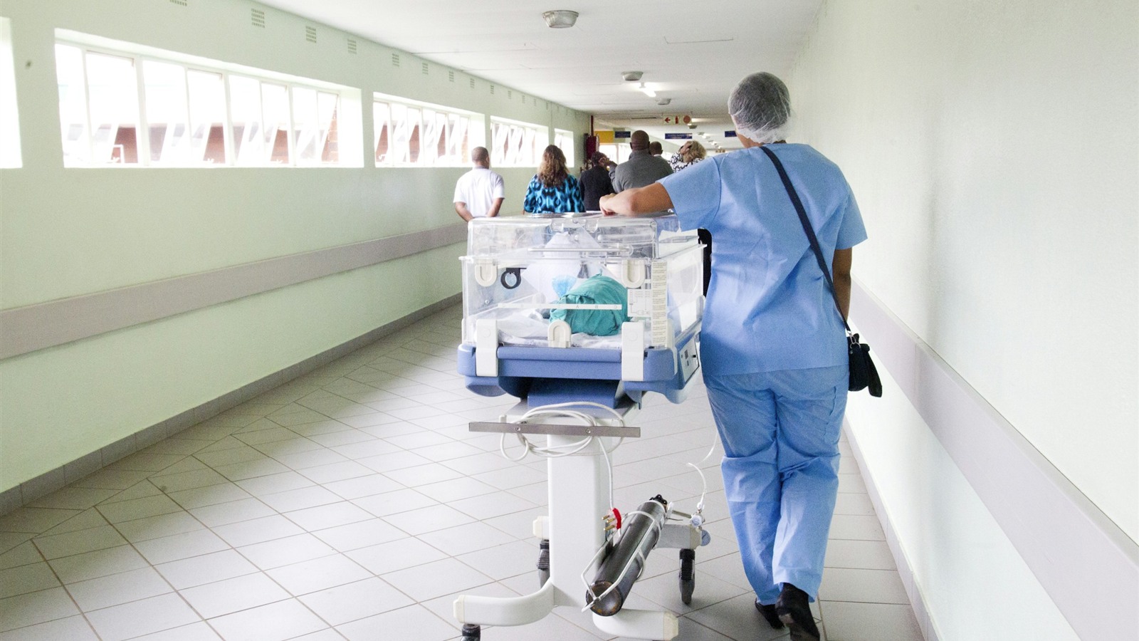 A nurse in scrubs walking a hospital corridor while planning a San Antonio home purchase with Velvet Realty Group